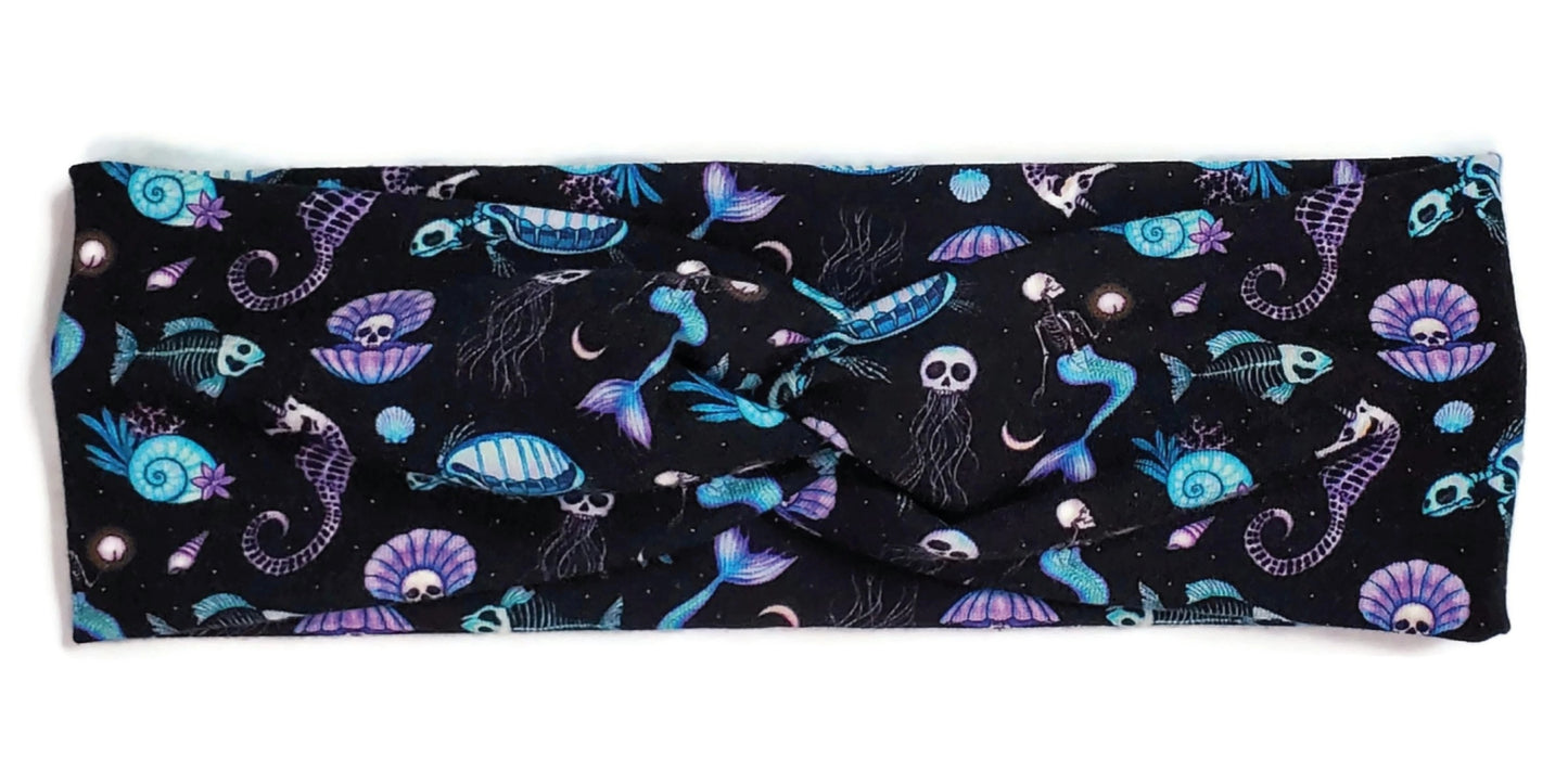 Spooky cute style purple and blue skeleton mermaids, seahorses, turtles, fish, Jellyfish and clams on a black twist headwrap headband for women