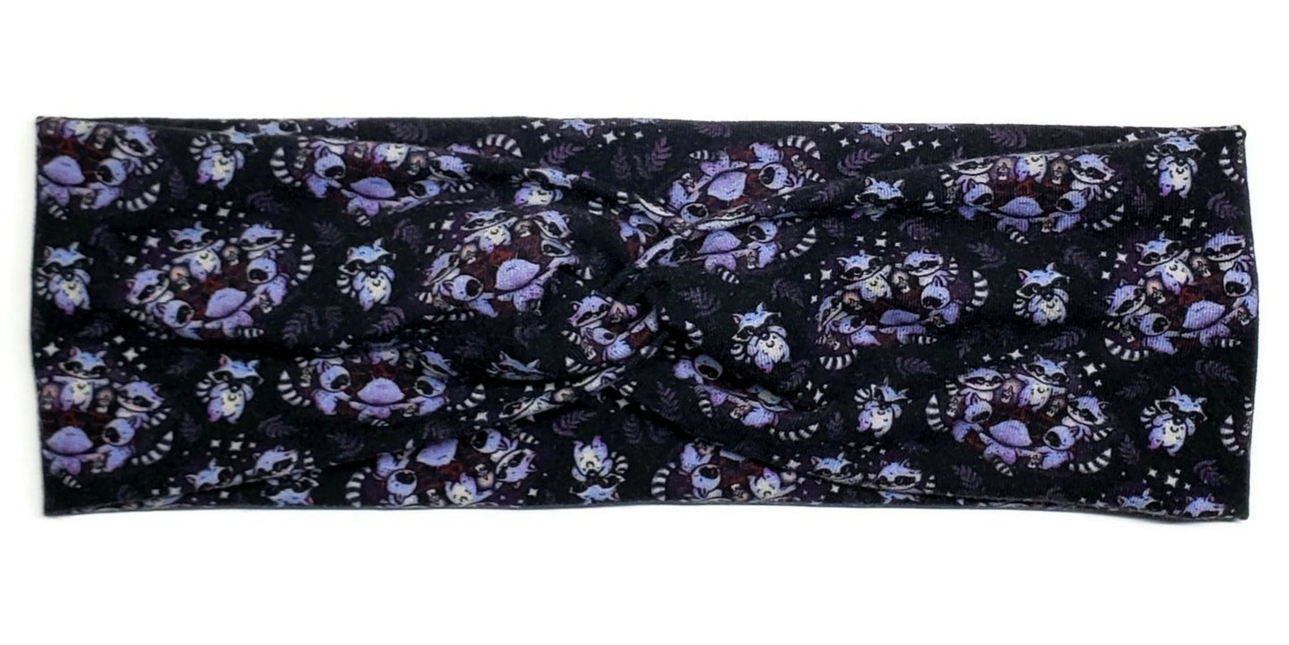 Purple pagan raccoons in a circle around pentagrams on a black twist headband for women