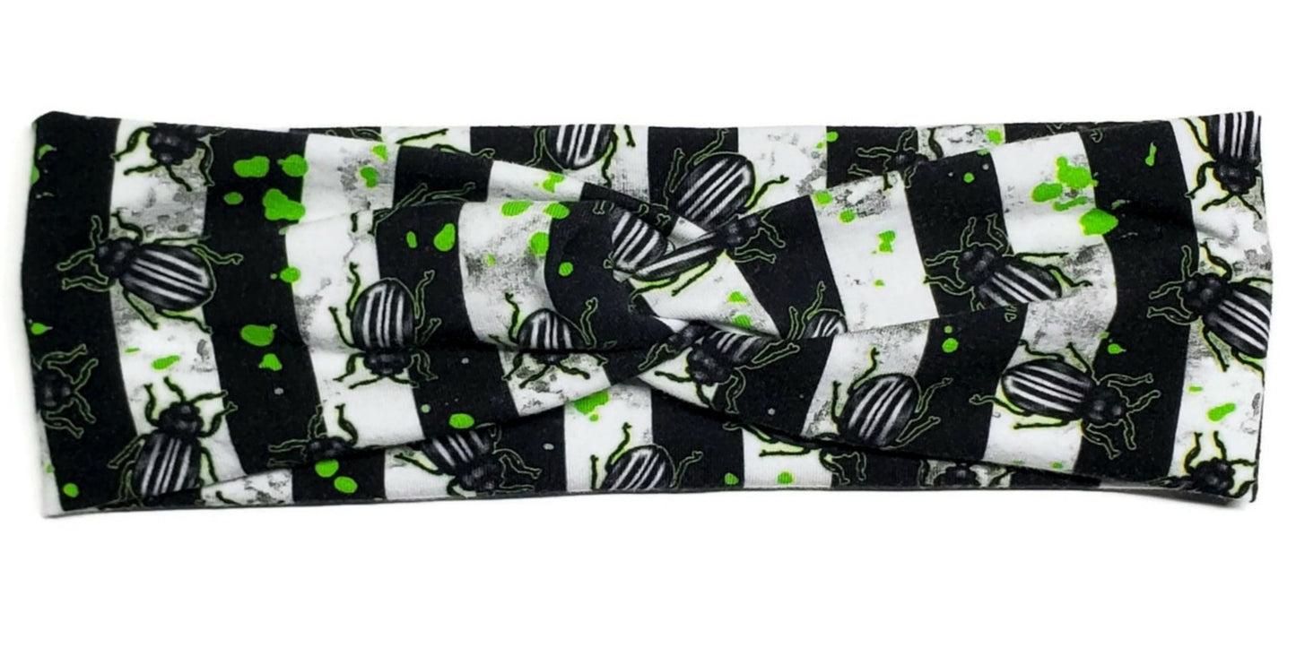 Beetles and green juice stains on a black and white striped twist headband for women